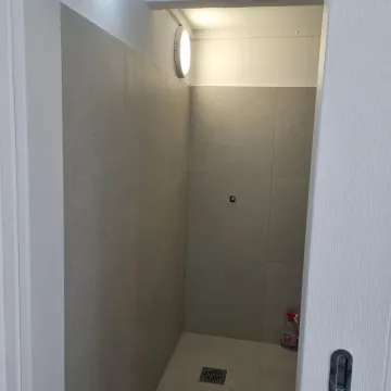 A modern shower area with grey wall and floor tiles. - image 4
