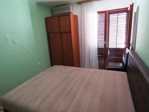 Jednostavna spavaća soba sa bračnim krevetom i drvenim ormarom. - image 4