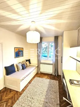 Small room with a bed, desk, and parquet flooring. - image 8
