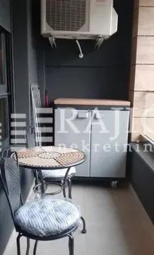 Smaller balcony with a table, chairs, and a cabinet. - image 6