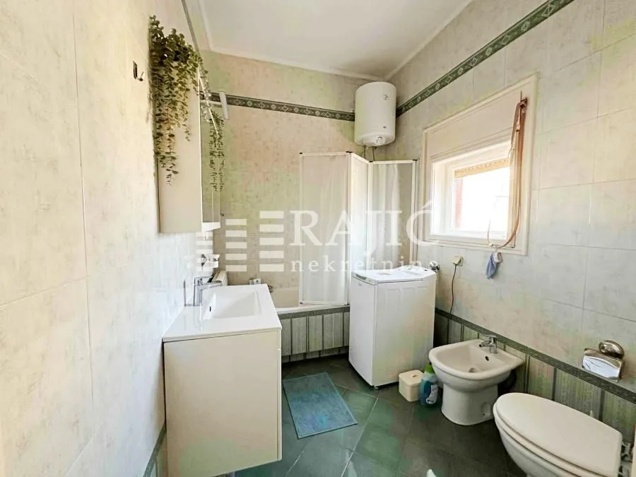 Fully equipped bathroom with a bathtub, sink, and washing machine.