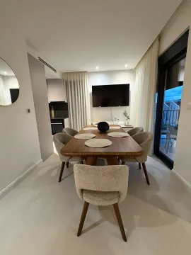Modern dining area with a wooden table and chairs, connected to the living room. - image 17