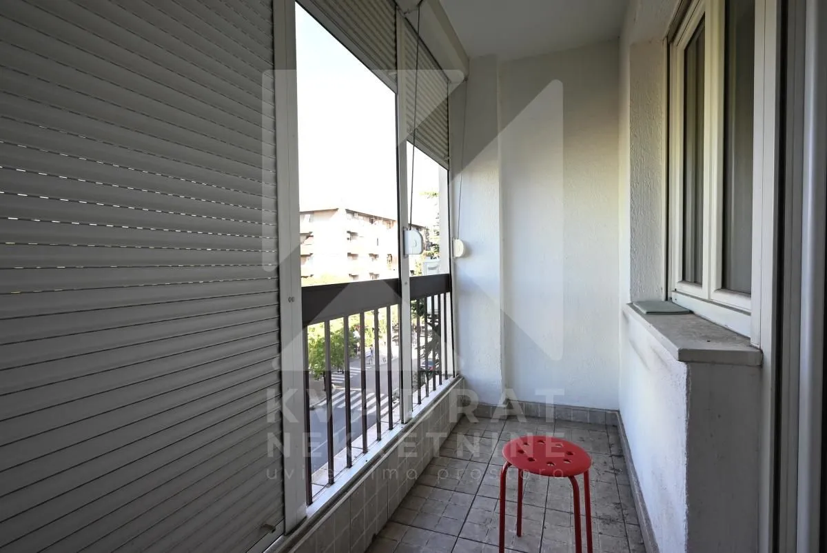 A view of the balcony with floor tiles and window shutters.