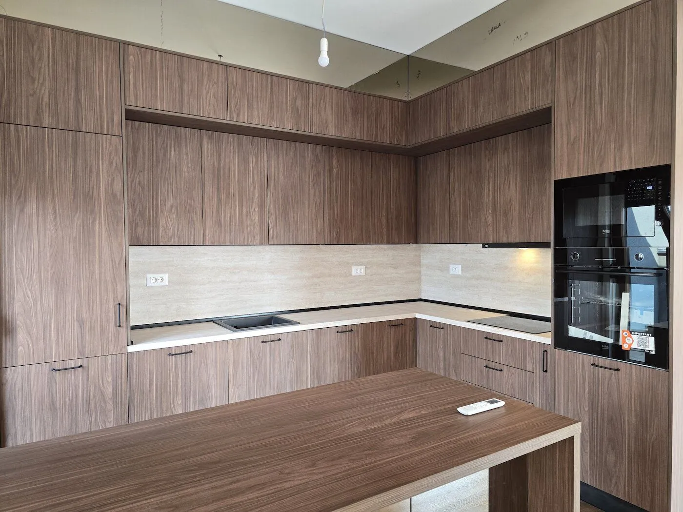 Modern kitchen with wooden cabinetry and a built-in oven.