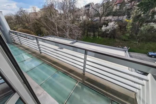 View from the balcony overlooking the surrounding greenery and street.