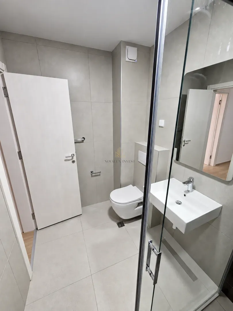 Moderno opremljeno kupatilo sa tuš kabinom, umivaonikom i WC šoljom.