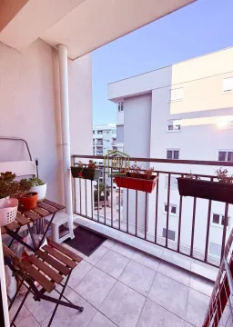 Namtješten balkon sa stolom, stolicama i saksijama sa cvijećem. - image 5
