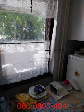 Pogled na kuhinjski prostor sa prozorom i čipkanim zavesama. - image 18