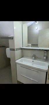 Modernly equipped bathroom with a sink and mirror. - image 8