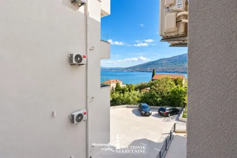 Pogled sa terase zgrade na dvorište, parking i more. - image 7