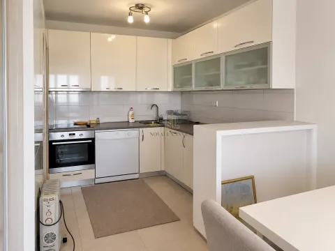 Modern white kitchen with built-in appliances and a dining area. - image 3