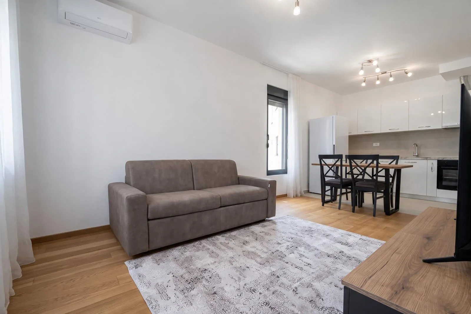 Living room with sofa and dining area in an open-plan layout.
