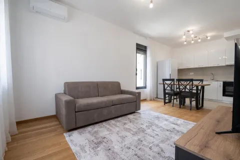 Living room with sofa and dining area in an open-plan layout. - image 2