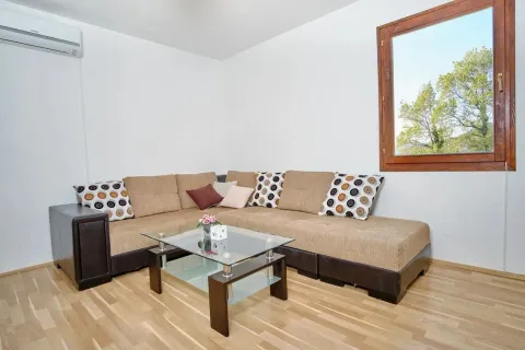 Living room with a sectional sofa, coffee table and a window. - image 9
