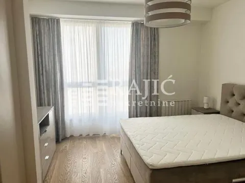 Furnished bedroom with a double bed and a curtained window. - image 5