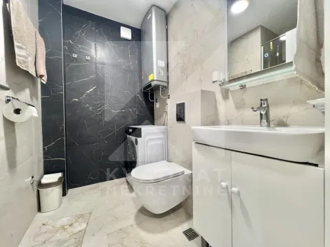 Modernly equipped bathroom with a washbasin, toilet, washing machine, and water heater. - image 7