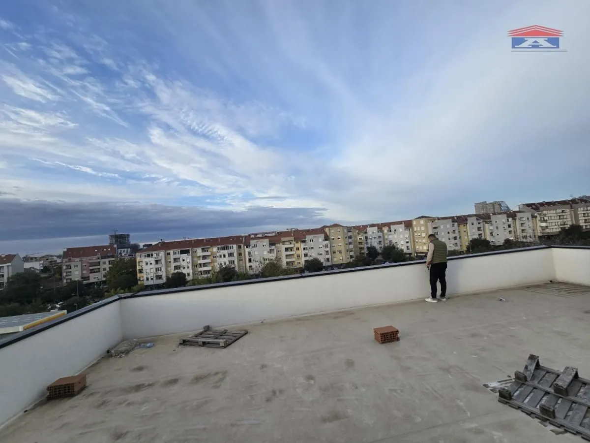Large unfurnished rooftop terrace with a city view.