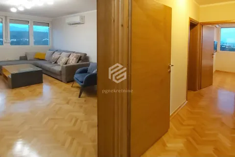 View from the hallway into the living room with a sofa and parquet flooring. - image 2