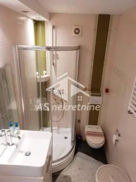 Compact bathroom with a shower cabin, washbasin, and toilet. - image 10