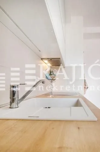Modern white kitchen with sink and countertop.