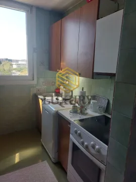 Smaller kitchen with cabinets and stove. - image 5