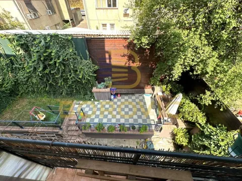 Pogled odozgo na popločano dvorište sa zelenilom i drvenom ogradom. - image 11