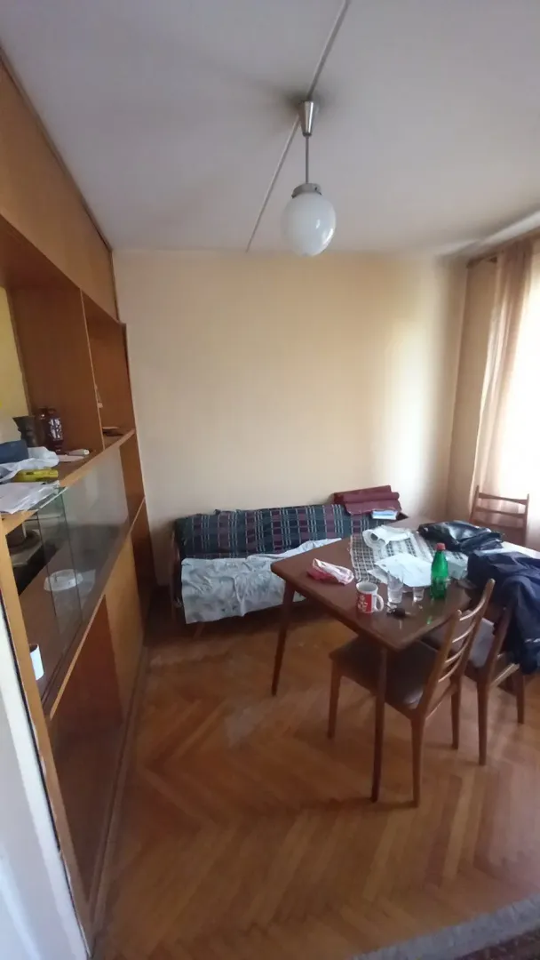 Dnevna soba sa trpezarijskim stolom i drvenim namještajem.
