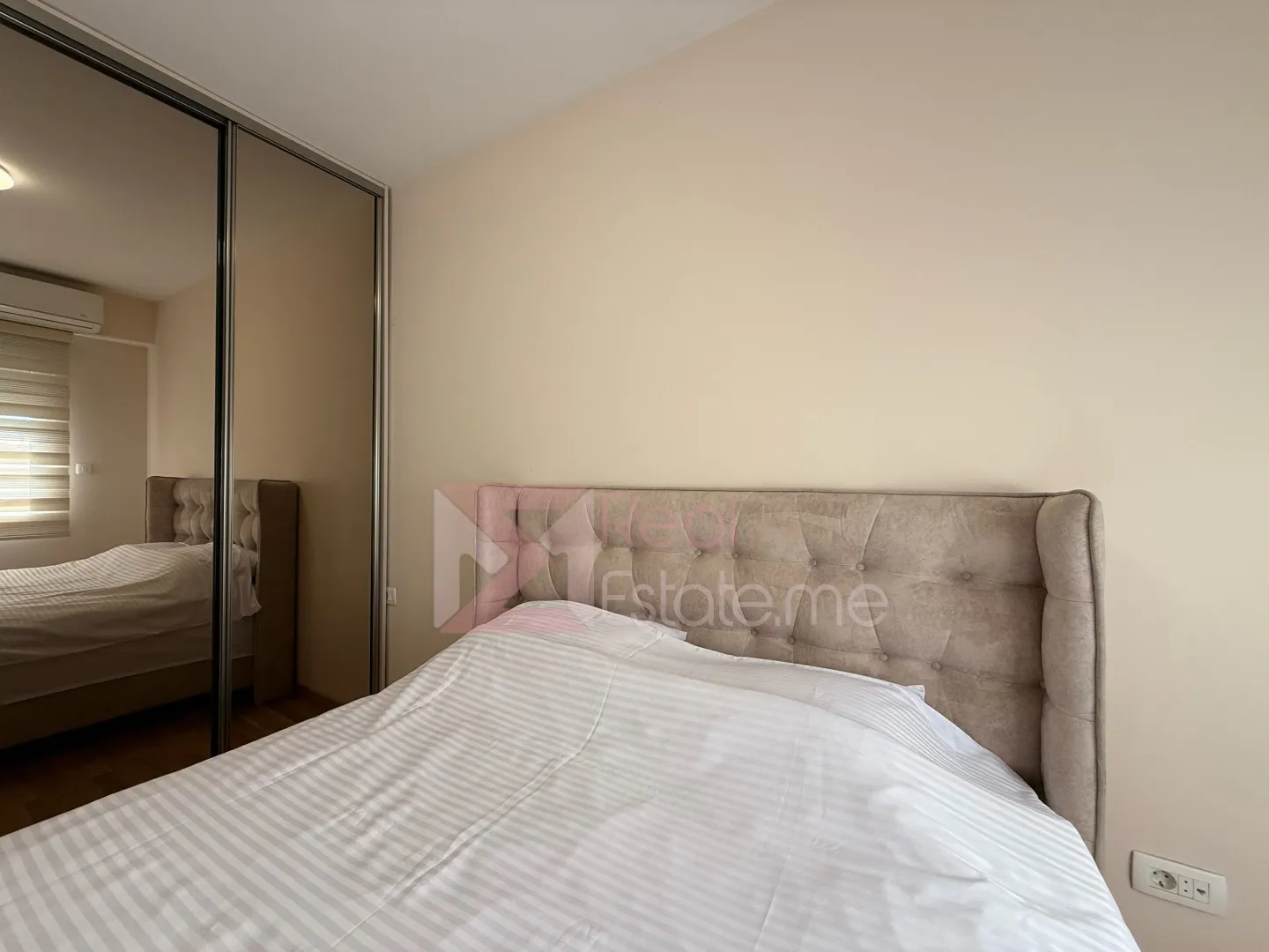 Tidy bedroom with a double bed and a large mirrored wardrobe.