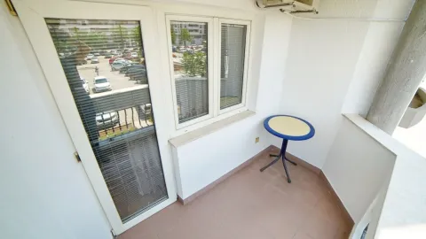 Bright balcony with tiled flooring and a small round table. - image 2