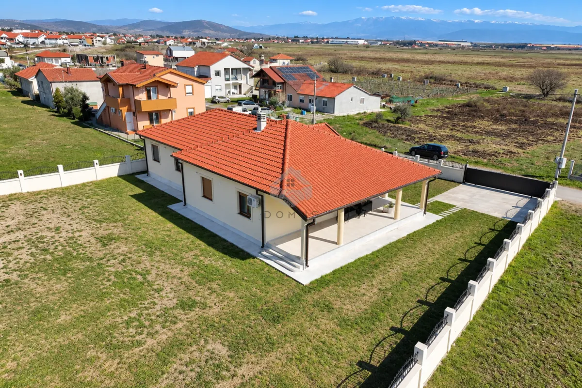 Aerial view of a single-story house with a landscaped yard and terrace.