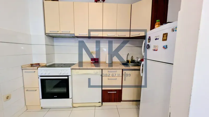 Smaller kitchen with light-toned cabinets and white goods.