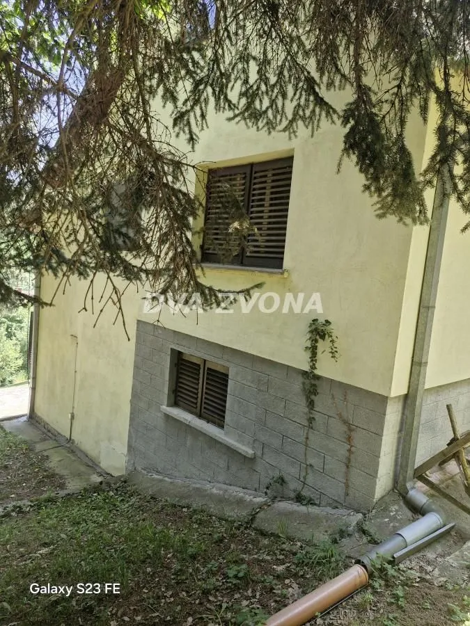 Pogled na spoljni deo kuće sa prozorima i dvorištem.