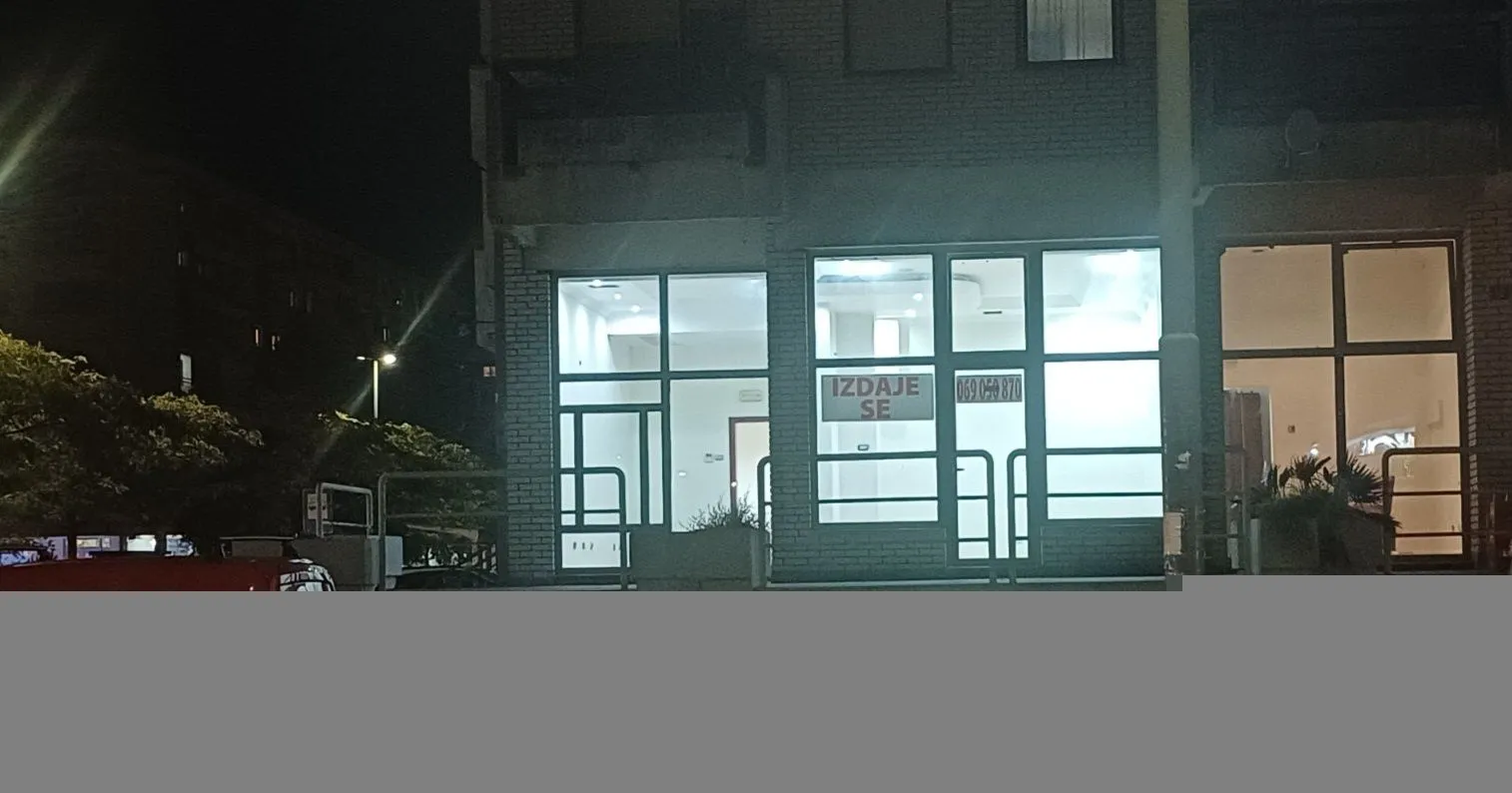 Night view of the exterior of the commercial space with a large glass storefront.