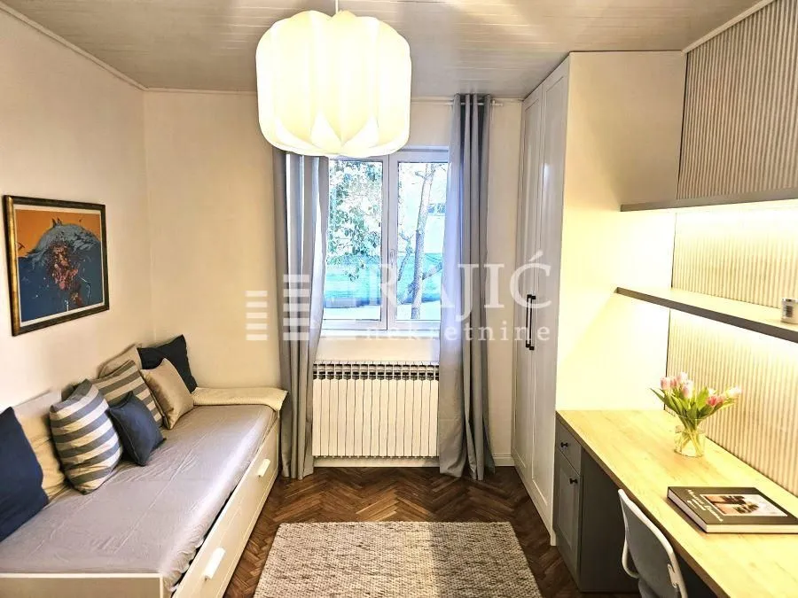 Small furnished bedroom with a bed and a desk.