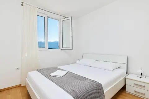 Svjetla spavaća soba sa bračnim krevetom i prozorom koji gleda na planine. - image 5
