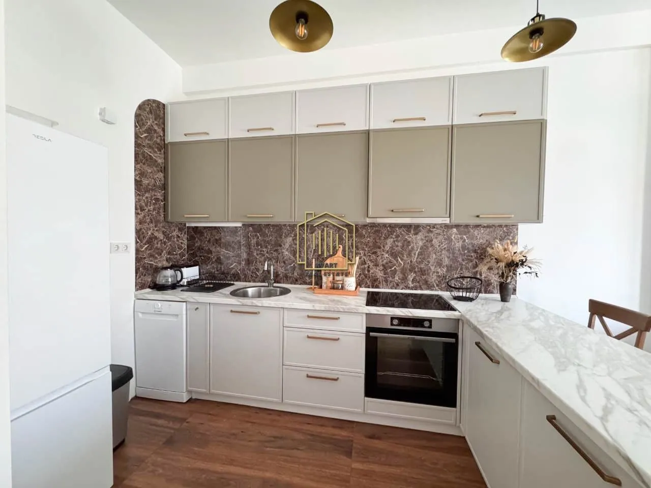 Modern kitchen equipped with built-in appliances and a marble countertop.