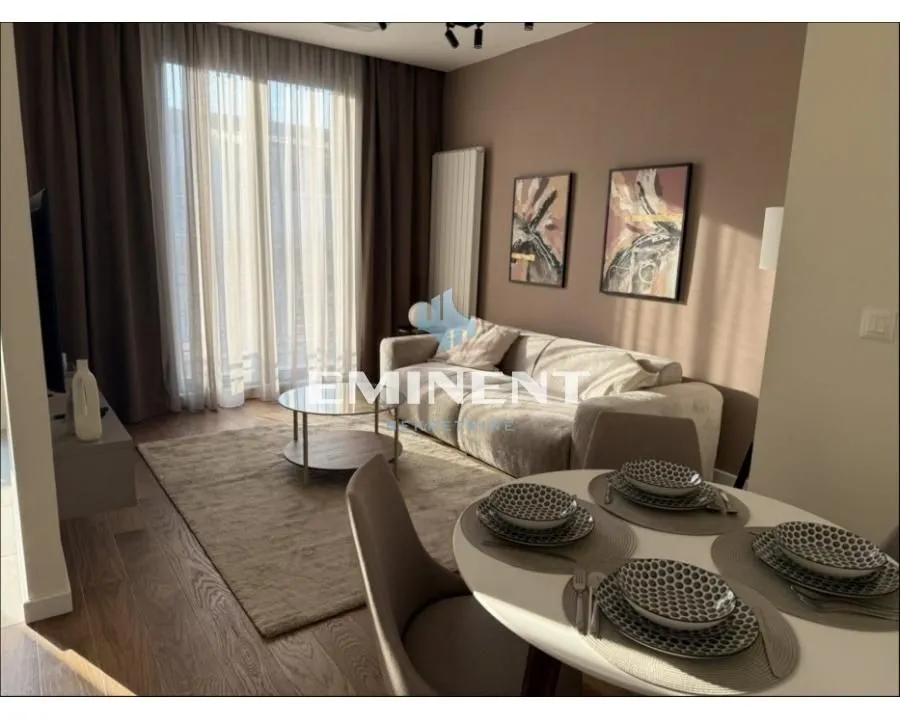 Living room with sofa, dining table, and access to the terrace.