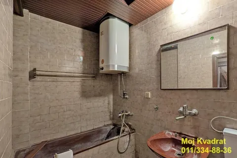 Kupatilo obloženo keramičkim pločicama sa kadom, lavaboom i bojlerom. - image 10