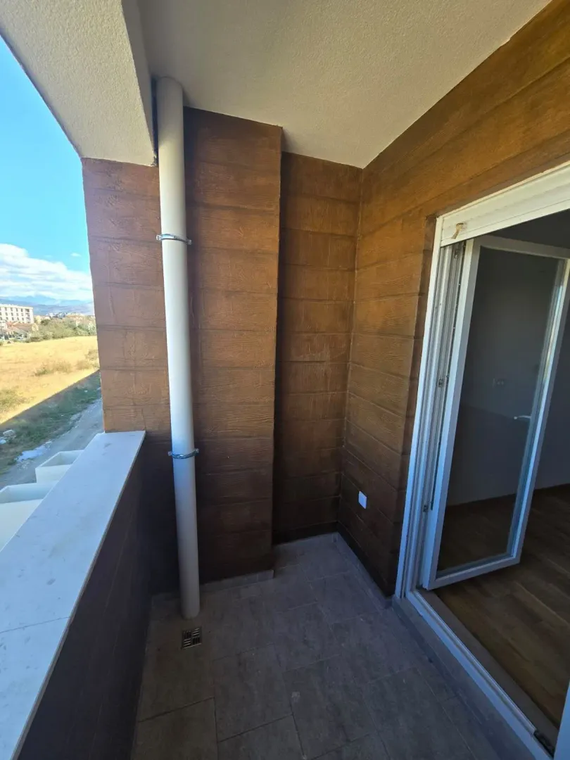 Manji zatvoreni balkon sa drvenom oblogom na zidu i izlazom u prostoriju.