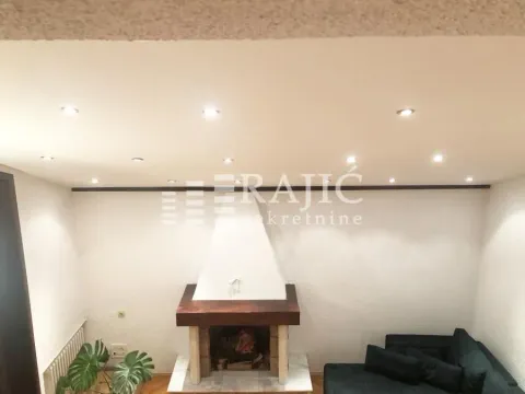 Living room with a fireplace and recessed ceiling lighting. - image 5