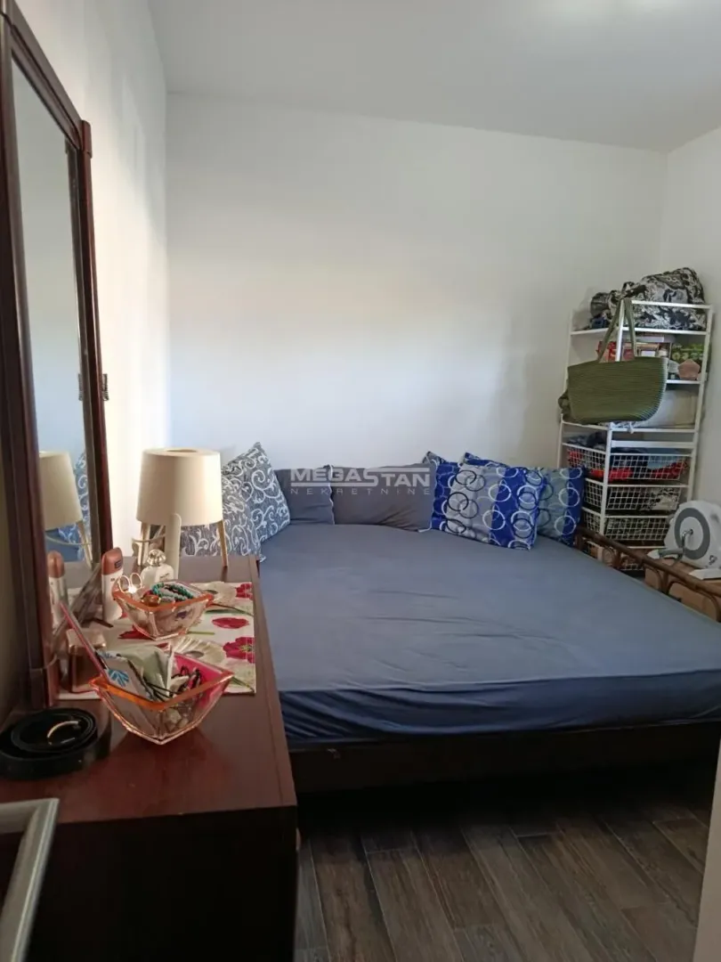 View of the bedroom with a double bed and a dresser with a mirror.