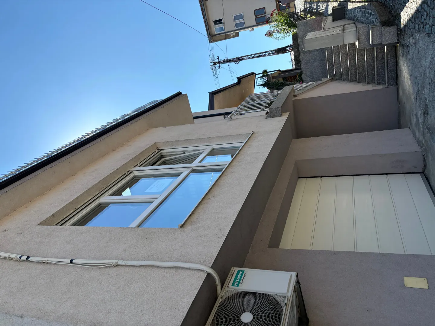 Exterior view of the house with stairs and a garage door.