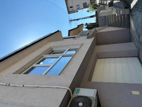 Exterior view of the house with stairs and a garage door. - image 4
