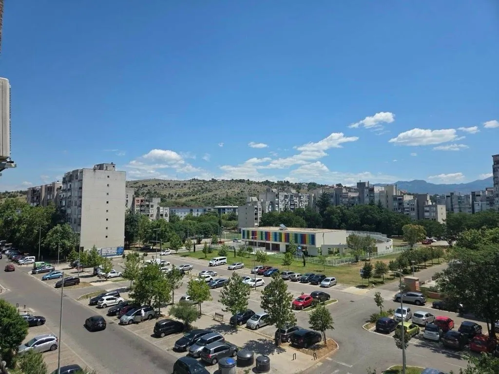 View from the terrace overlooking the neighborhood, parking lot, and green areas.
