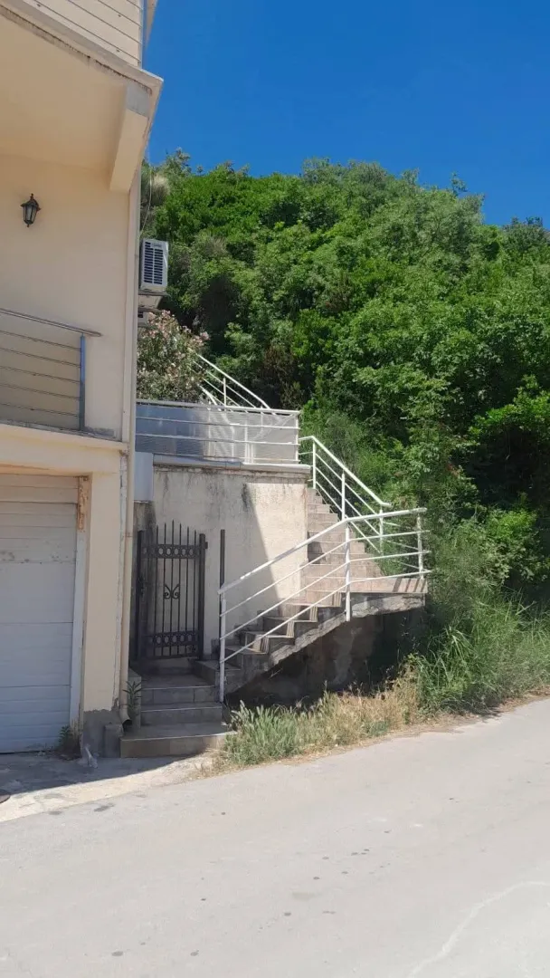 Spoljašnji dio kuće sa stepeništem i ulaznim vratima.