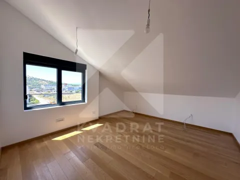 Empty attic room with hardwood floors and a window. - image 22
