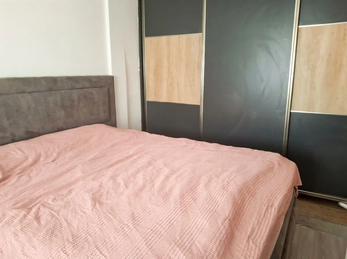 Spavaća soba sa bračnim krevetom i velikim ugradnim garderoberom.