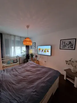 Prostrana spavaća soba sa bračnim krevetom, TV-om na zidu i krevetcem za bebe. - image 14