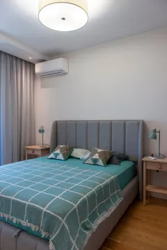 Modern bedroom with a double bed, bedside tables, and an air conditioner. - image 13