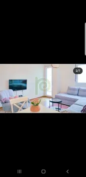 Bright living room with a sofa and TV. - image 2